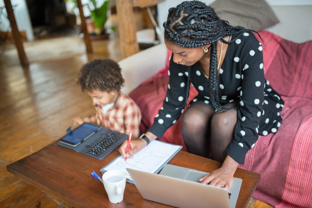 Child Care and Development Resources - Mother multitasking with work and child at home, showcasing modern parenting.