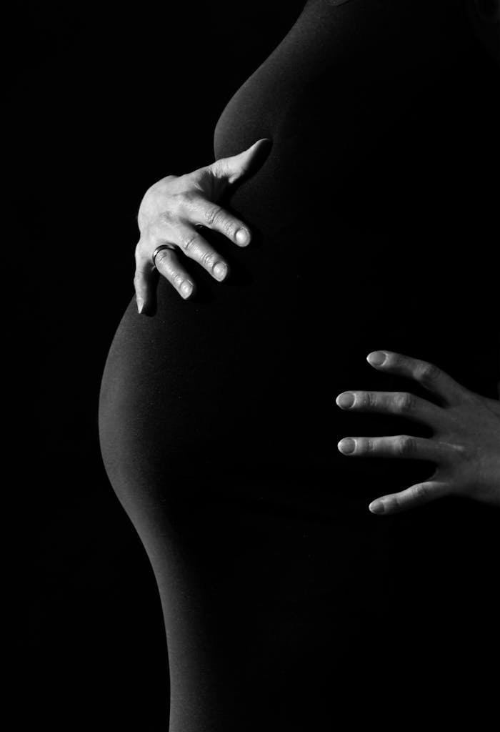 pregnancy-woman-belly-hands-46207 Resources - Artistic black and white portrait of pregnant woman embracing belly.